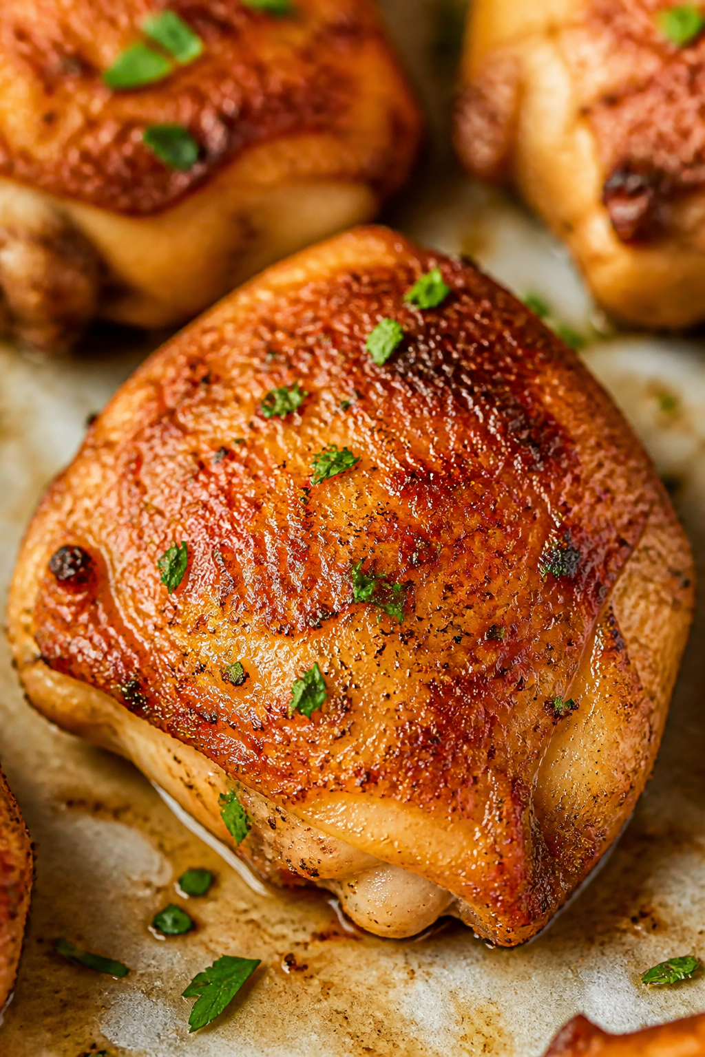 Close-up detail: Golden, oven-baked ranch chicken thigh fresh from the sheet pan, skin blistered and