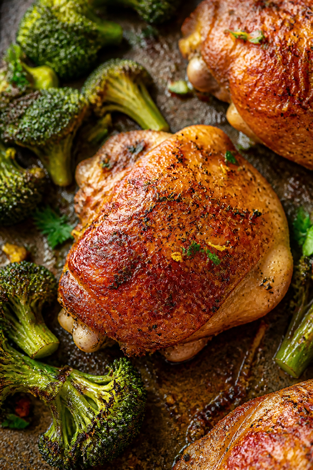 Close-up detail: Golden, roasted bone-in chicken thigh skin crackling with deep paprika color and gl