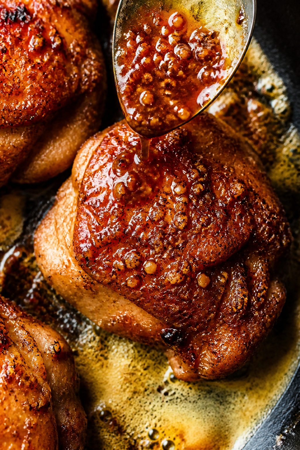 Cooking process, close-up detail: Searing brown sugar garlic chicken thighs skin-side down in a larg