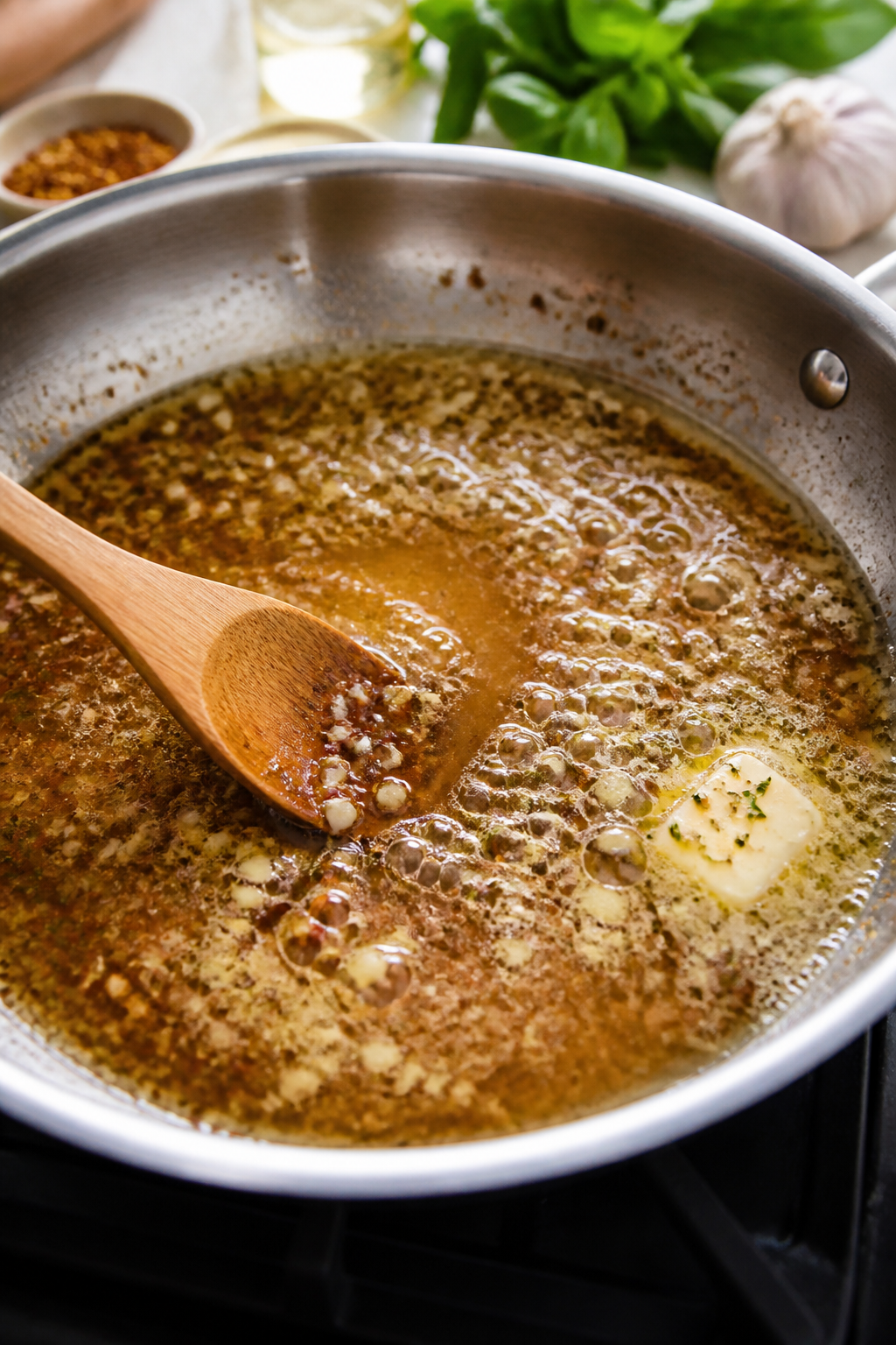 Cooking process: Deglazing in action—white wine and chicken broth bubbling in a skillet after saut