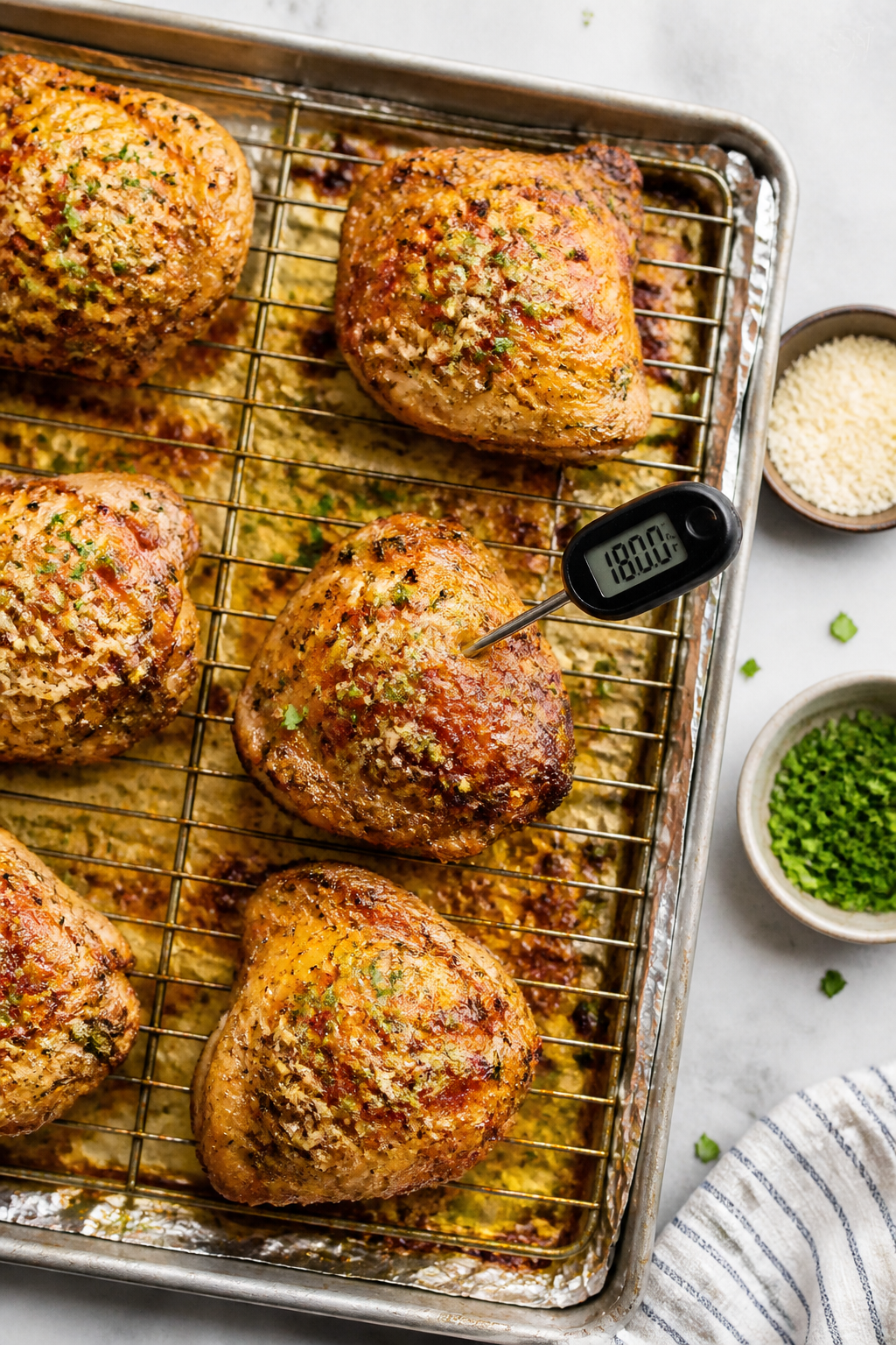 Cooking process: Overhead shot of chicken thighs roasting on a wire rack set over a foil-lined sheet