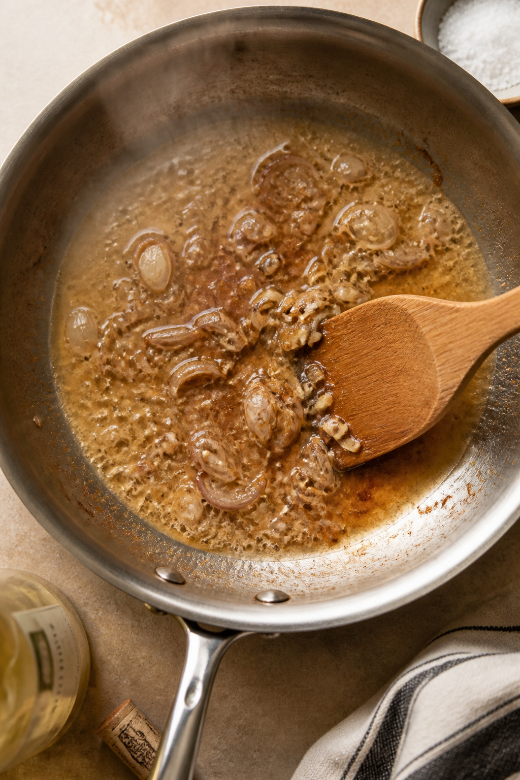 Cooking process: Overhead shot of deglazing the fond in a wide skillet—shallots and lightly golden