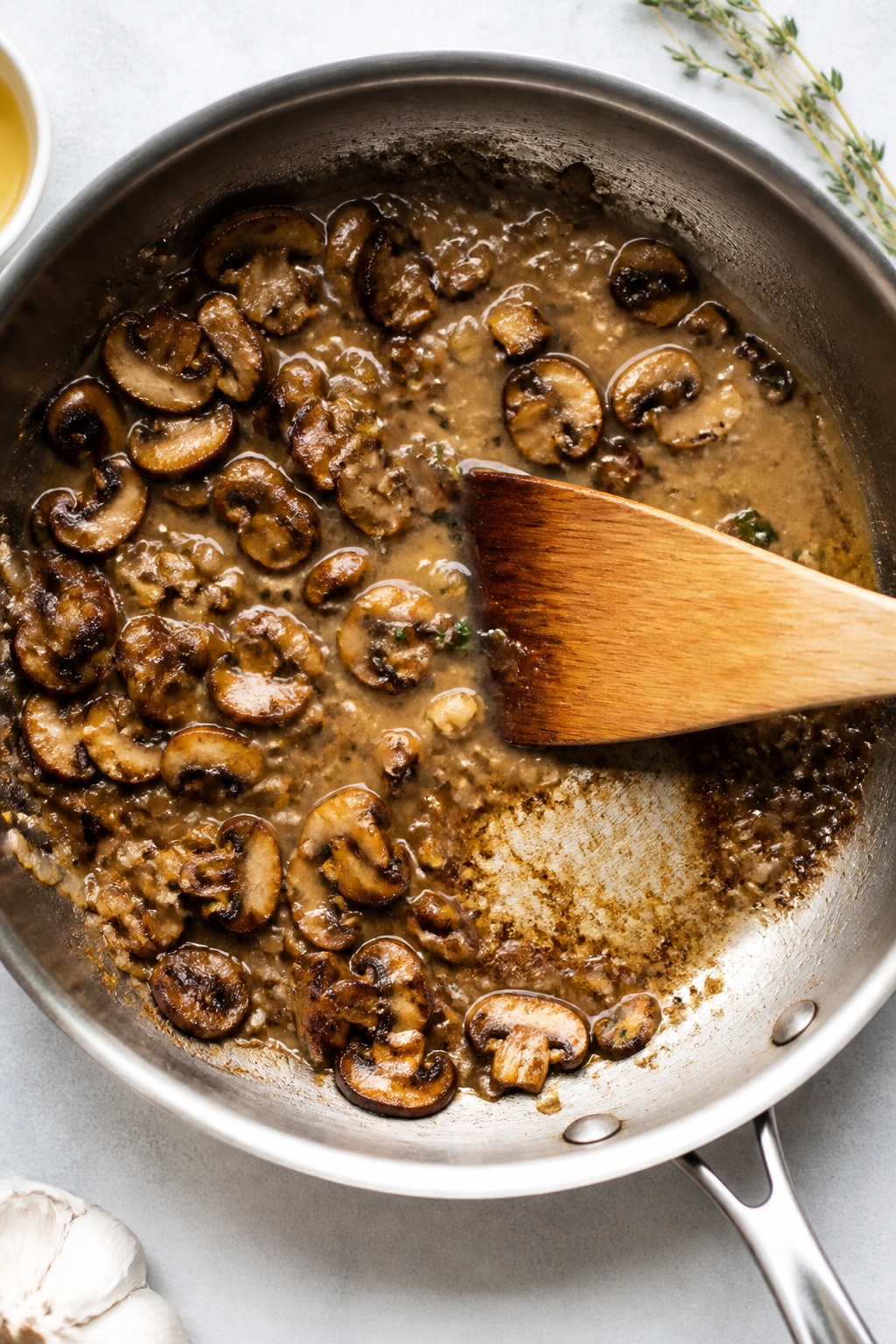 Cooking process: Overhead shot of the deglazing stage—mushrooms, shallots, and garlic sautéed to 