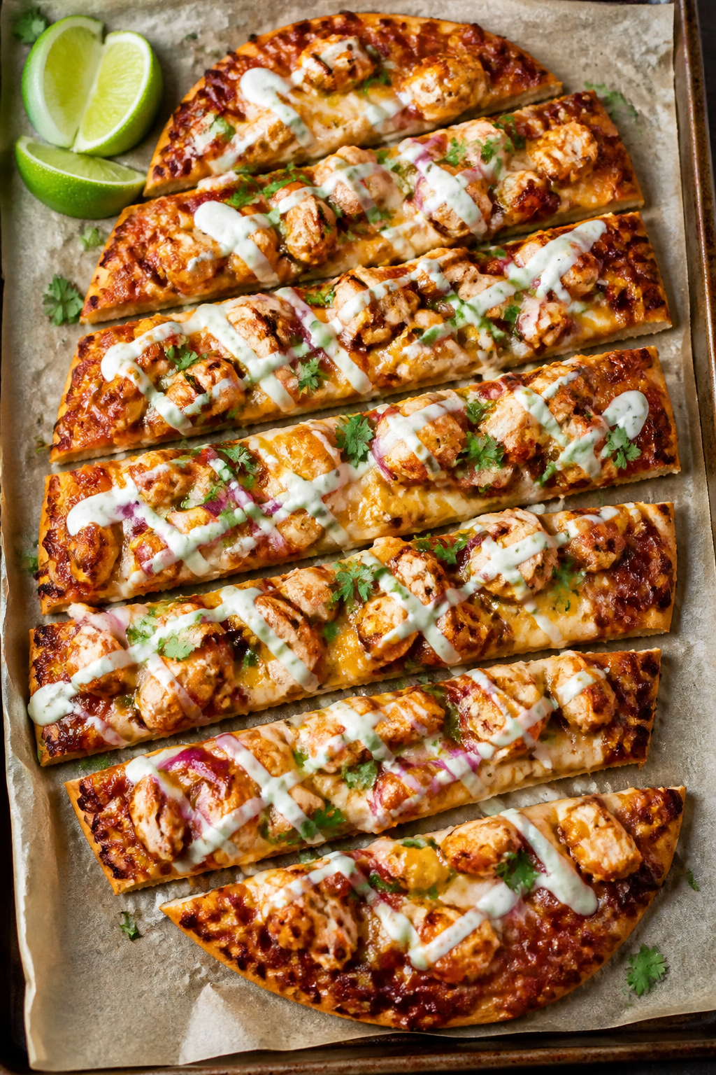 Overhead “tasty top view”: Fully baked BBQ Chicken Ranch Flatbread Pizza on a parchment-lined sh