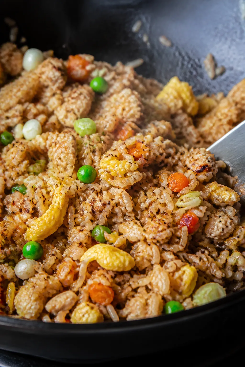 Close-up detail: Ground chicken fried rice sizzling in a carbon steel wok during the “fry the rice