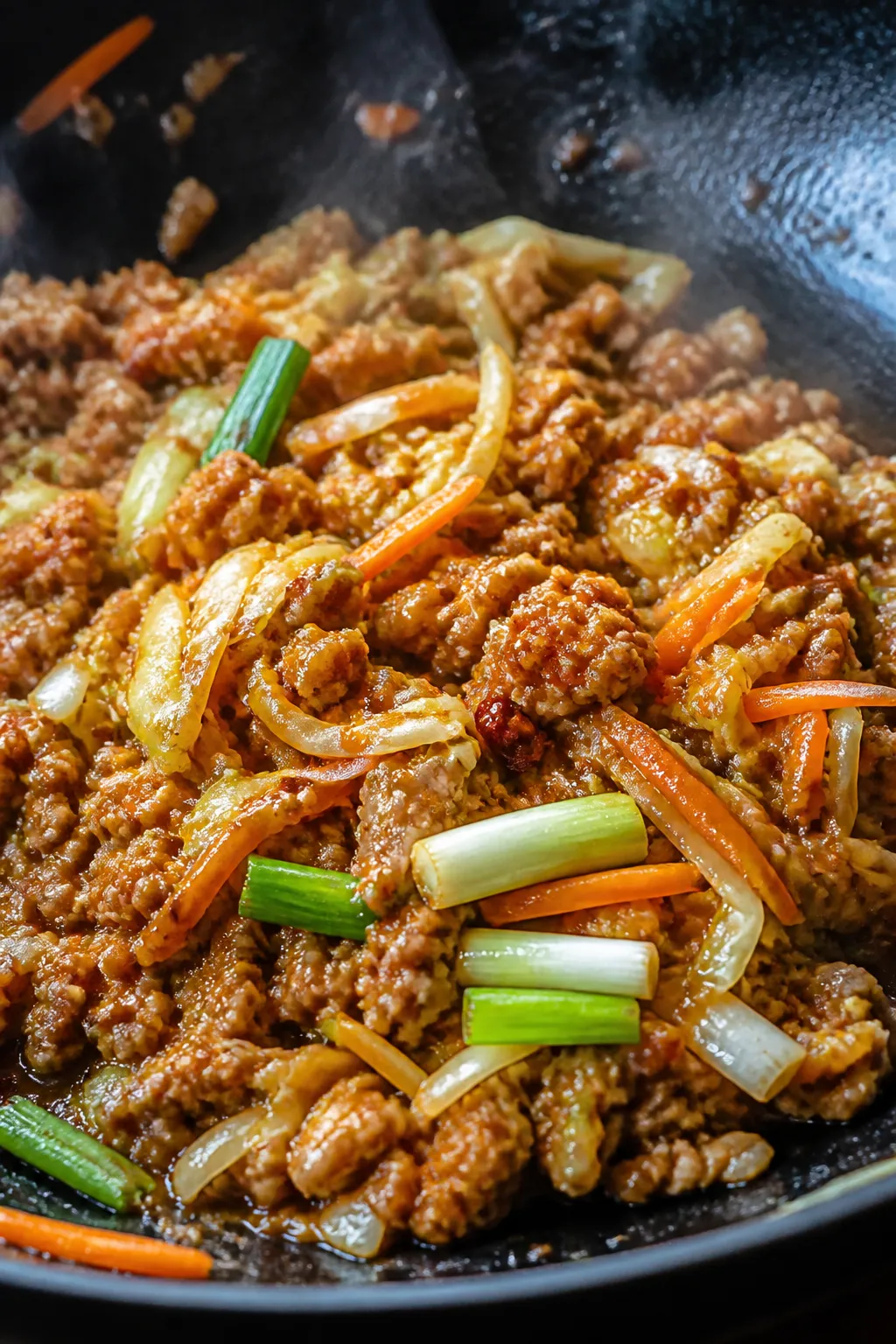 Close-up detail shot: Savory ground chicken crack slaw sizzling in a wok just after the sauce is add
