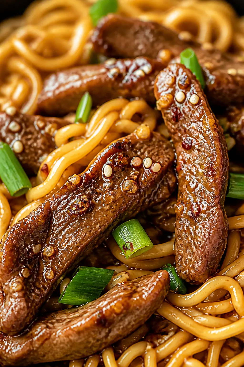 Close-up detail — Velvet-soft beef and noodles: extreme close-up of tender, browned beef strips cl