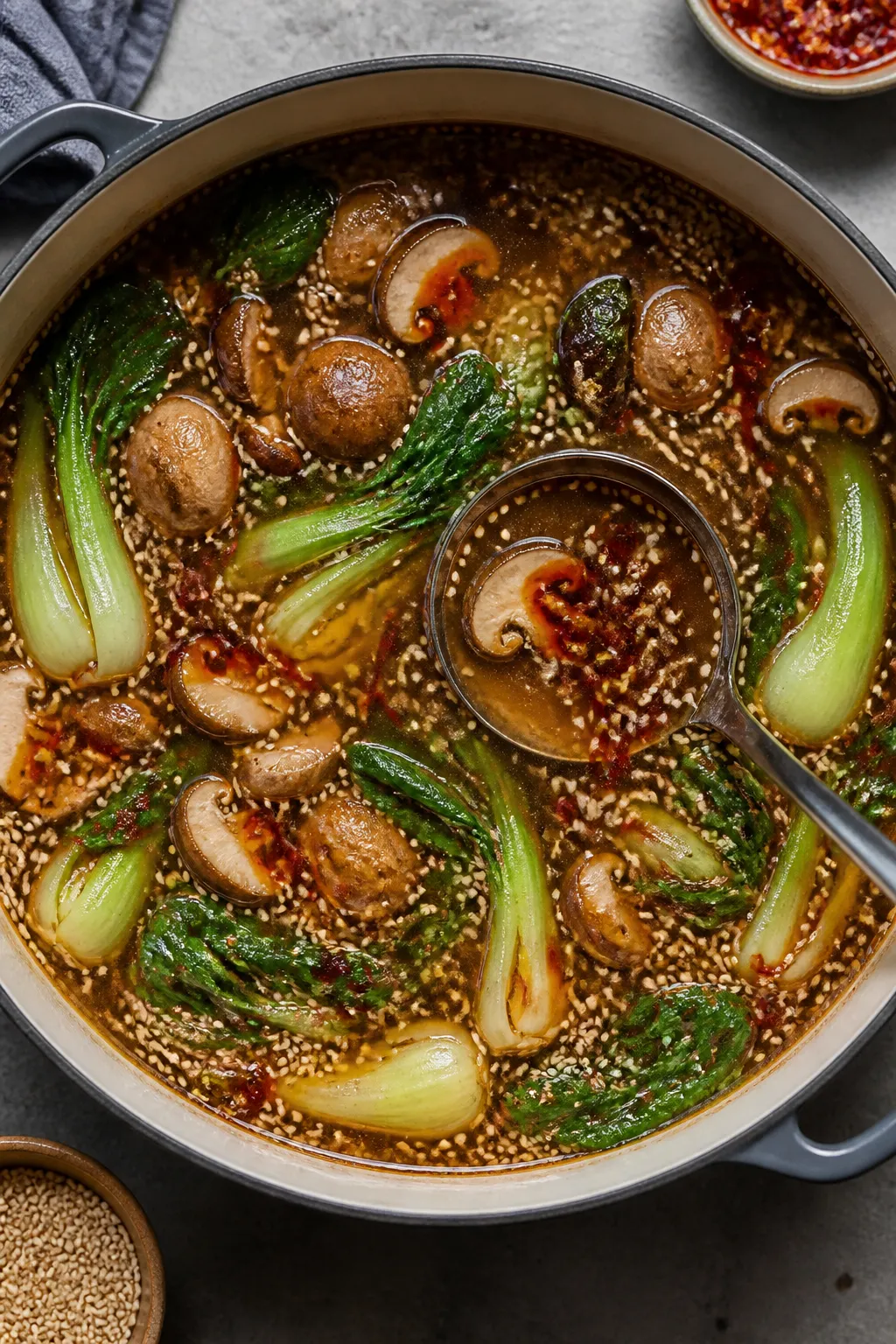 Cooking process overhead: Simmering garlic-sesame broth in a wide pot, overhead shot showing soy-dar