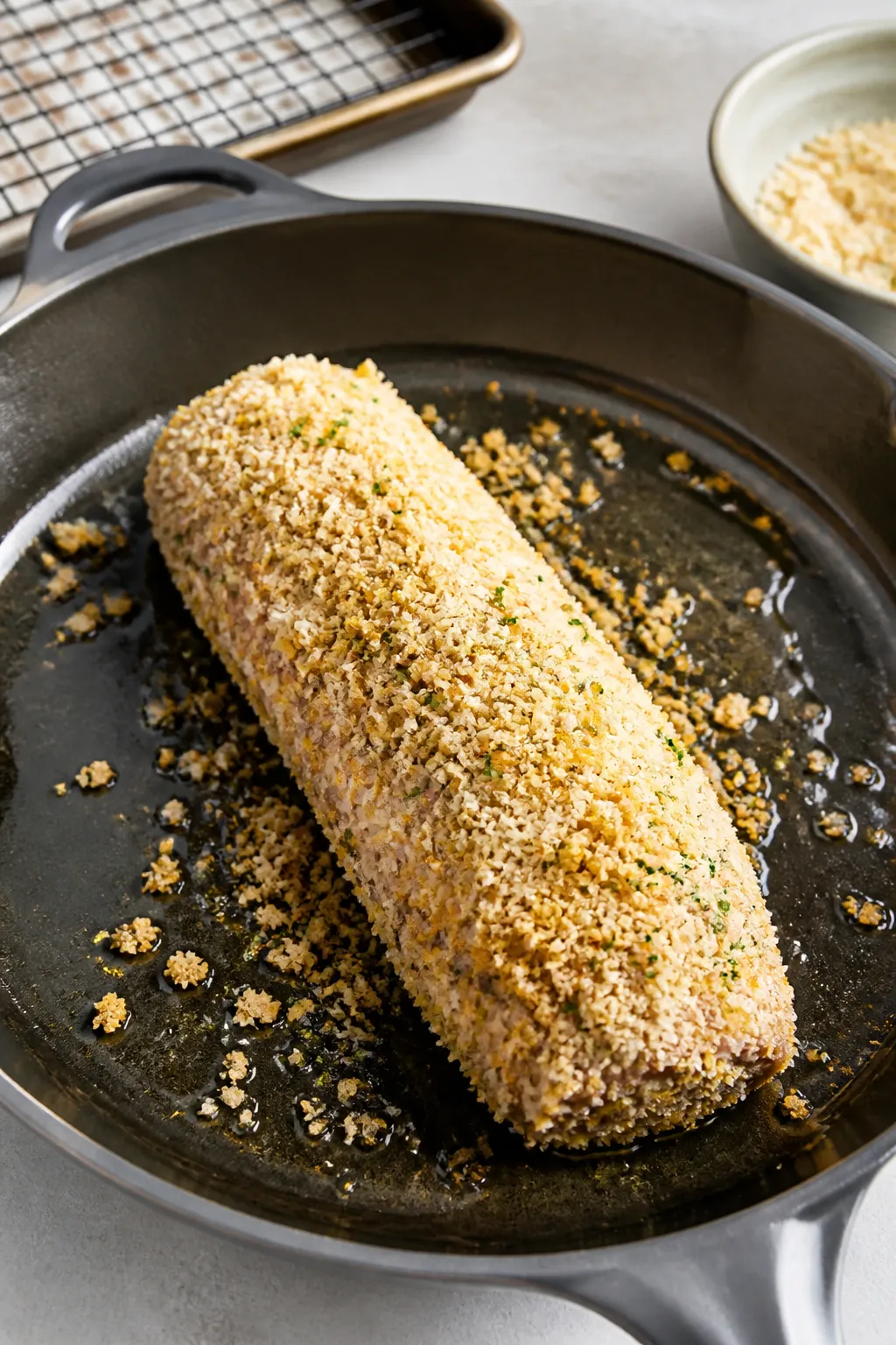 Cooking process shot: the seared pork tenderloin in an oven-safe skillet right before roasting, full