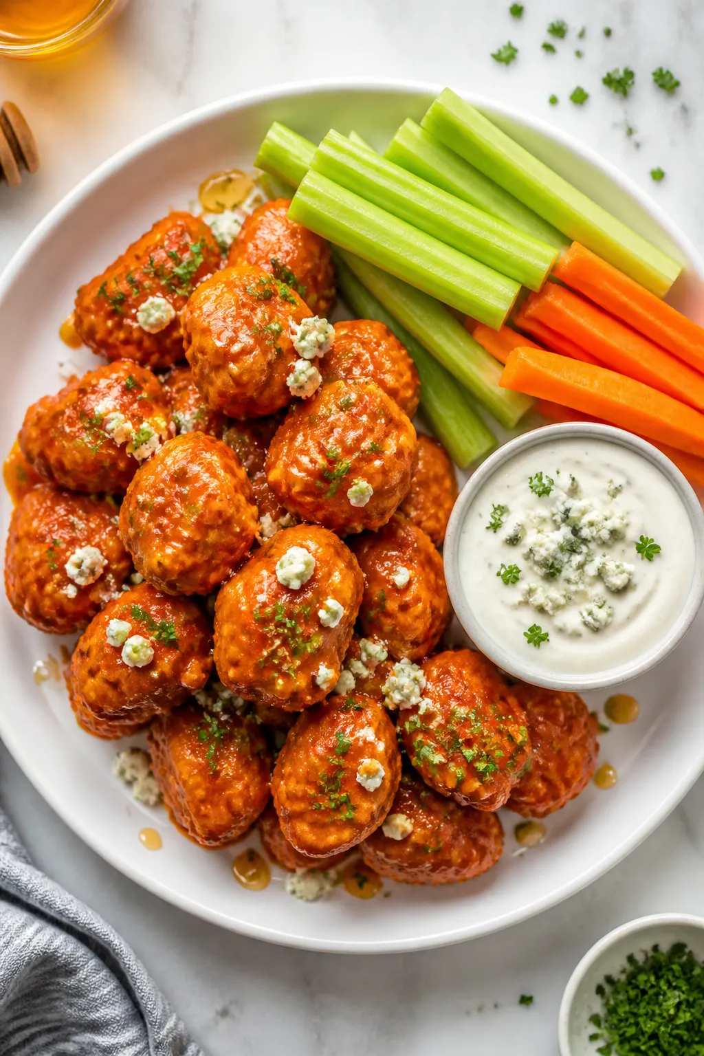 Final plated dish: Restaurant-quality presentation of buffalo chicken bites piled on a white shallow