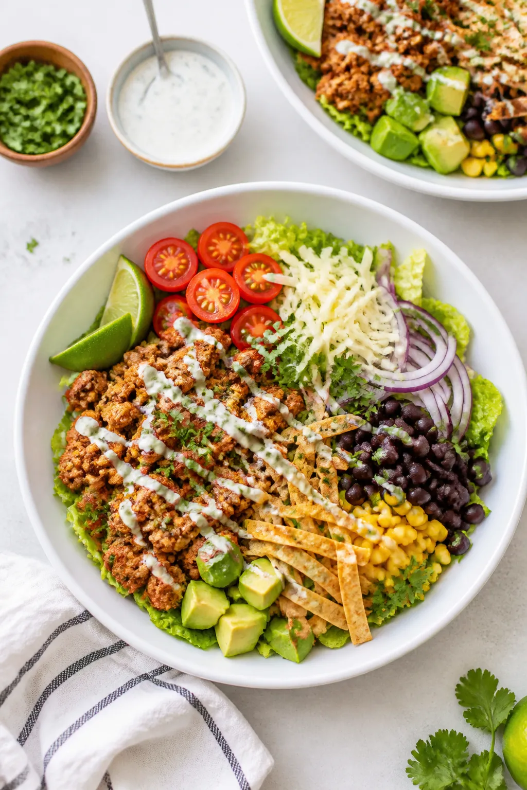 Tasty top view: Overhead shot of assembled Ground Chicken Taco Salad Bowls in wide white bowls—cri