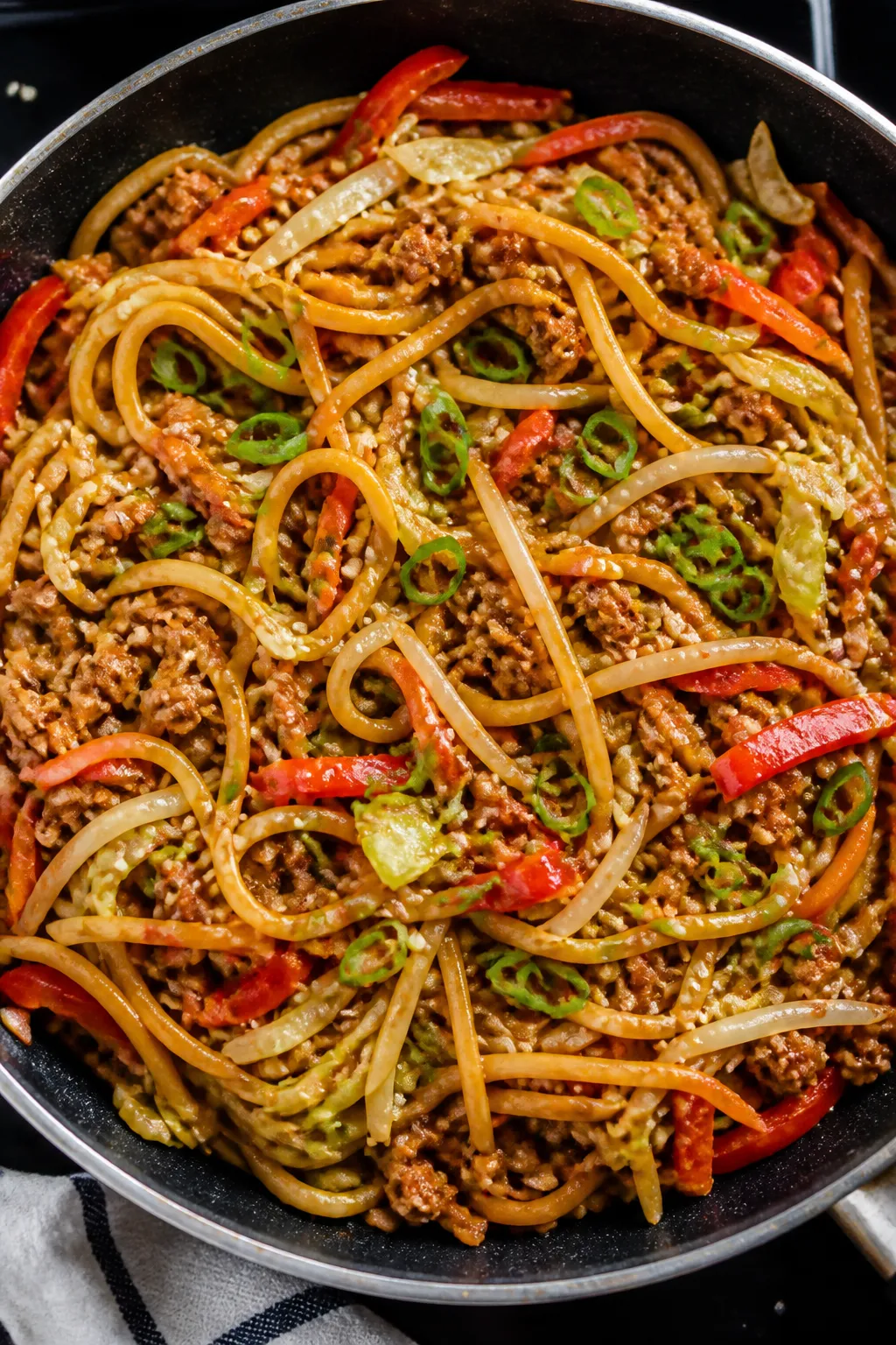 Tasty top view: Overhead shot of Ground Chicken Lo Mein just finished in the pan, noodles coiled and