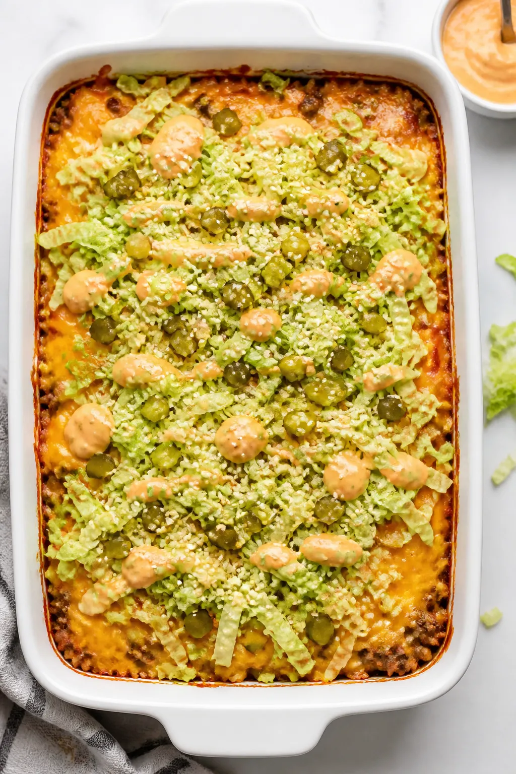 Tasty top view: Overhead shot of the baked Healthy Big Mac Casserole in a 9x13 white baking dish, ch